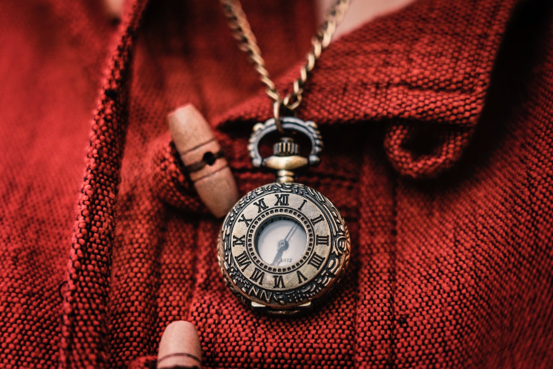 gold colored chain necklace with watch pendant