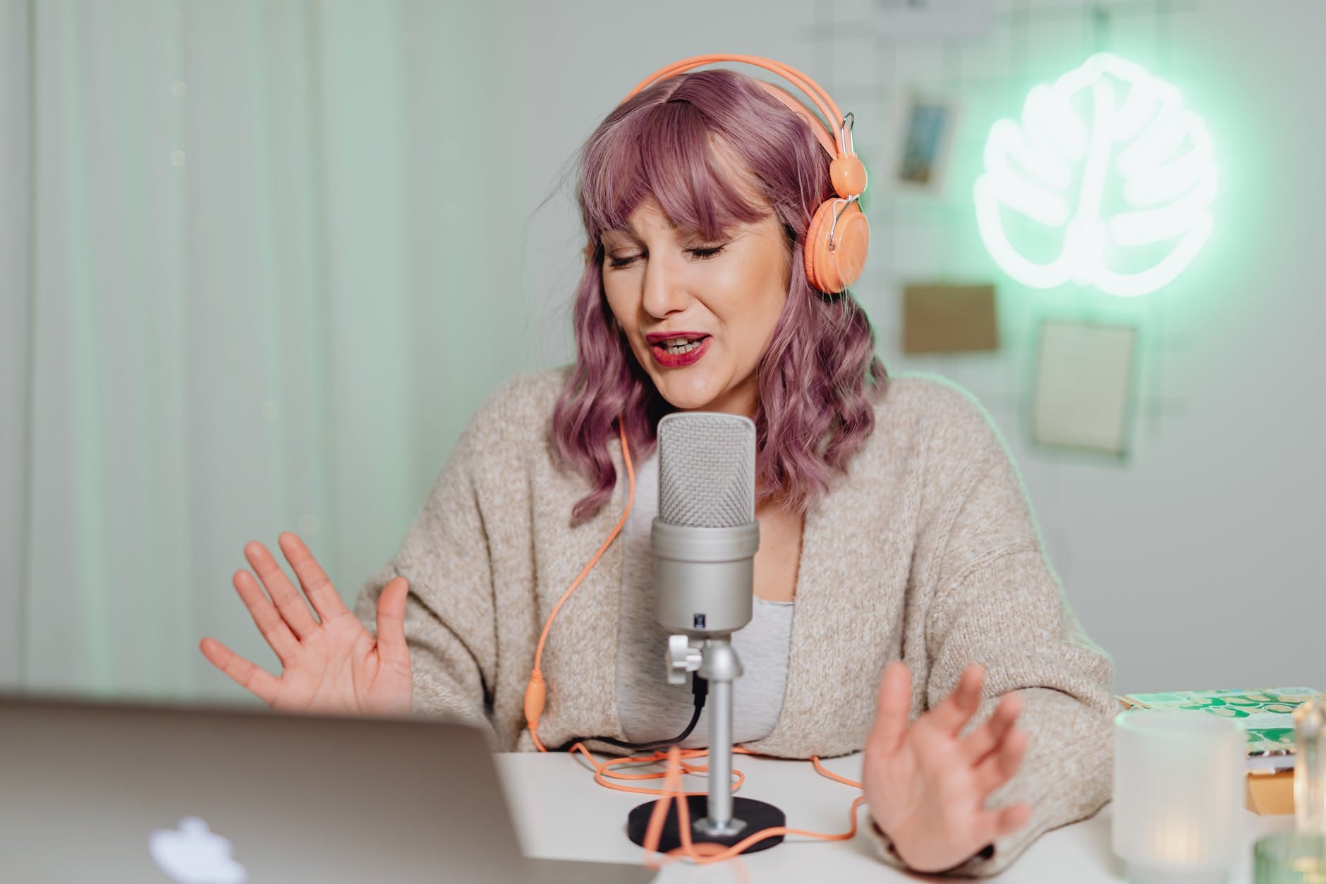 a woman talking on a microphone while wearing a headphone