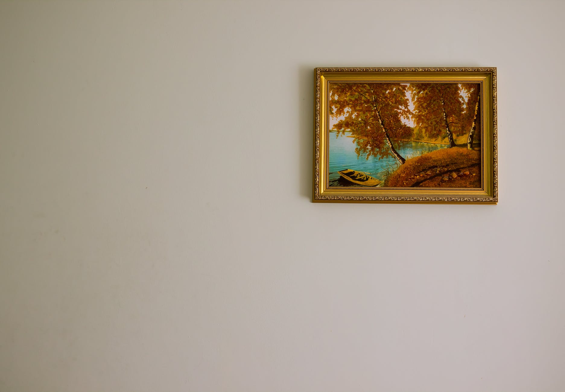 a single gold framed painting on the wall