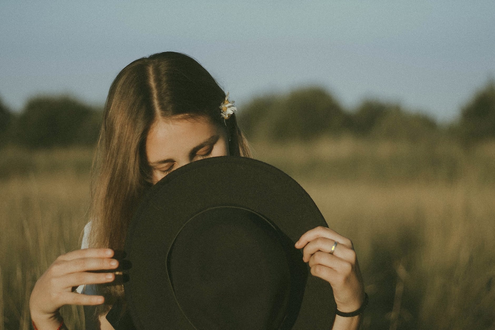 unrecognizable girl covering face with hat