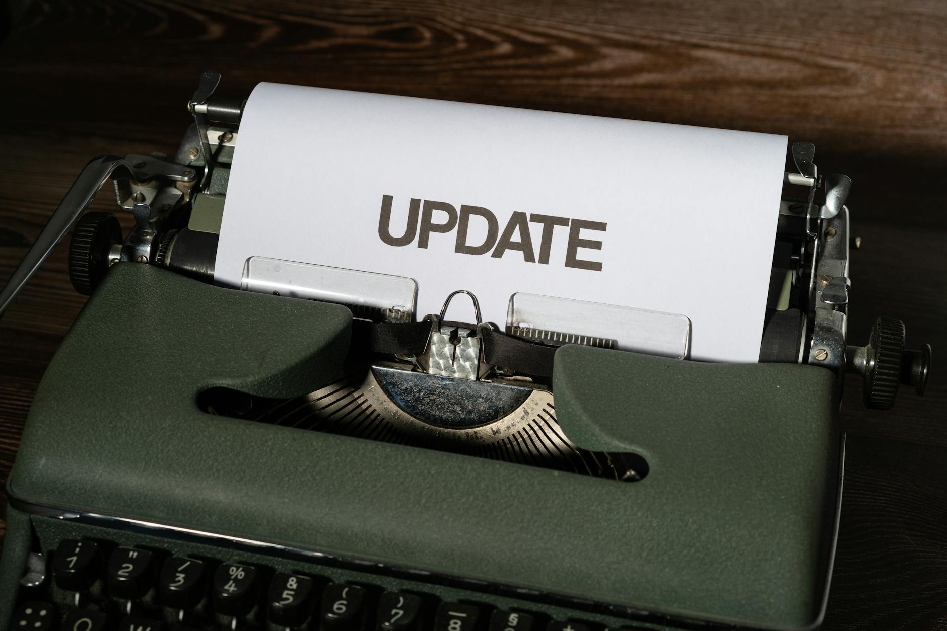 green classic typewriter with white paper