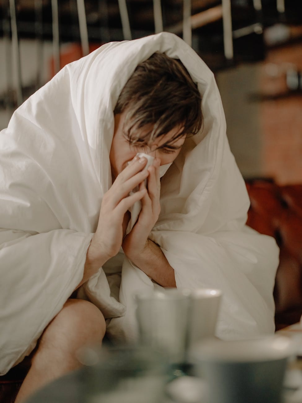 a sick man wiping his nose with tissue